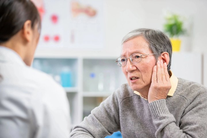 Senior woman talking to the dentists in winter park fl about ear pain