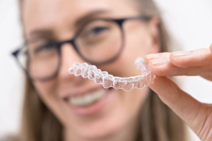 woman with glasses holding invisalign winter park