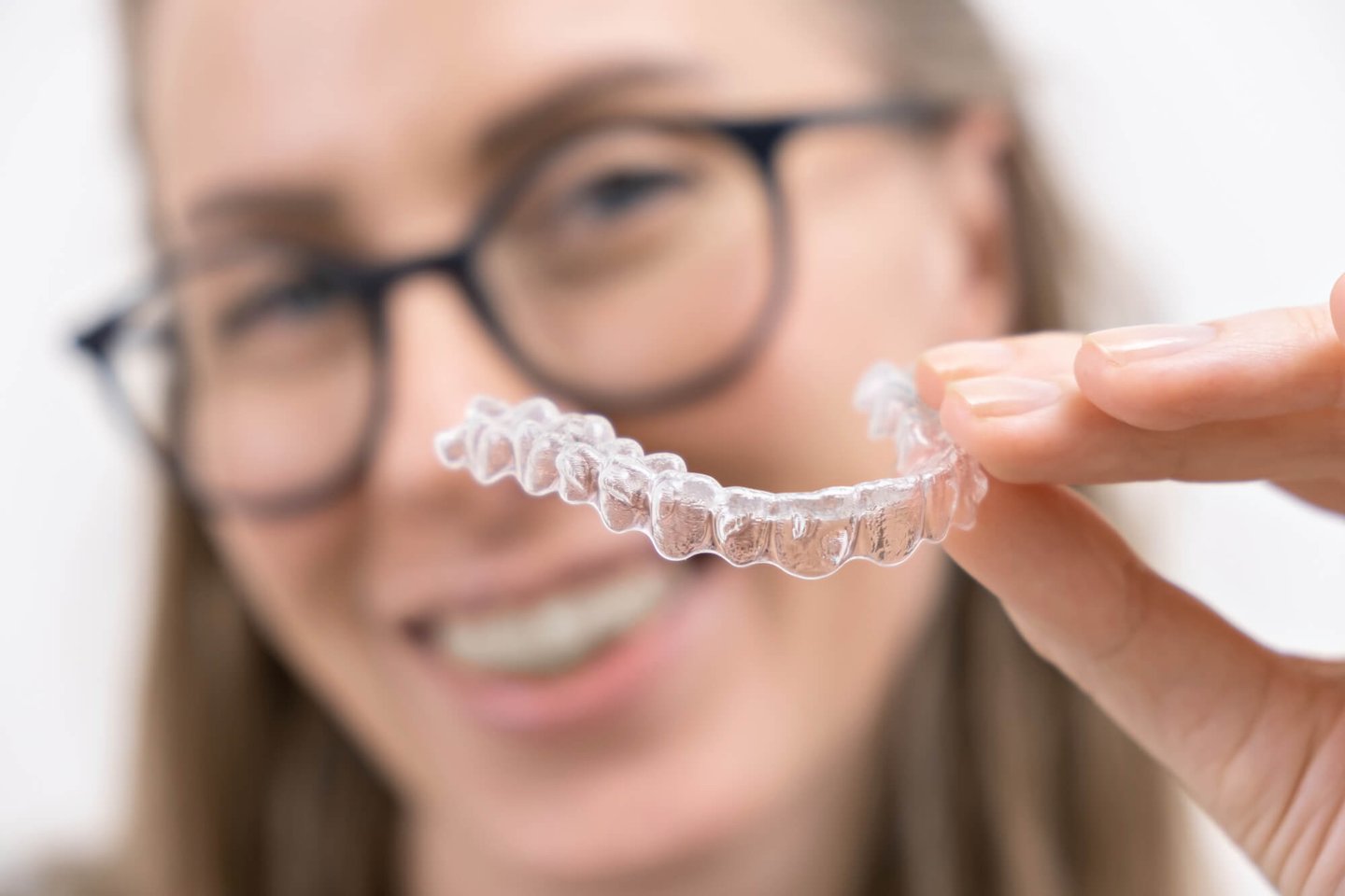 woman with glasses holding invisalign winter park