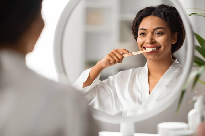 woman brushing after teeth whitening winter park