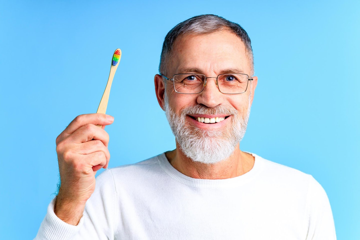 eldelry man holds a toothbrush as advised by dentist winter park