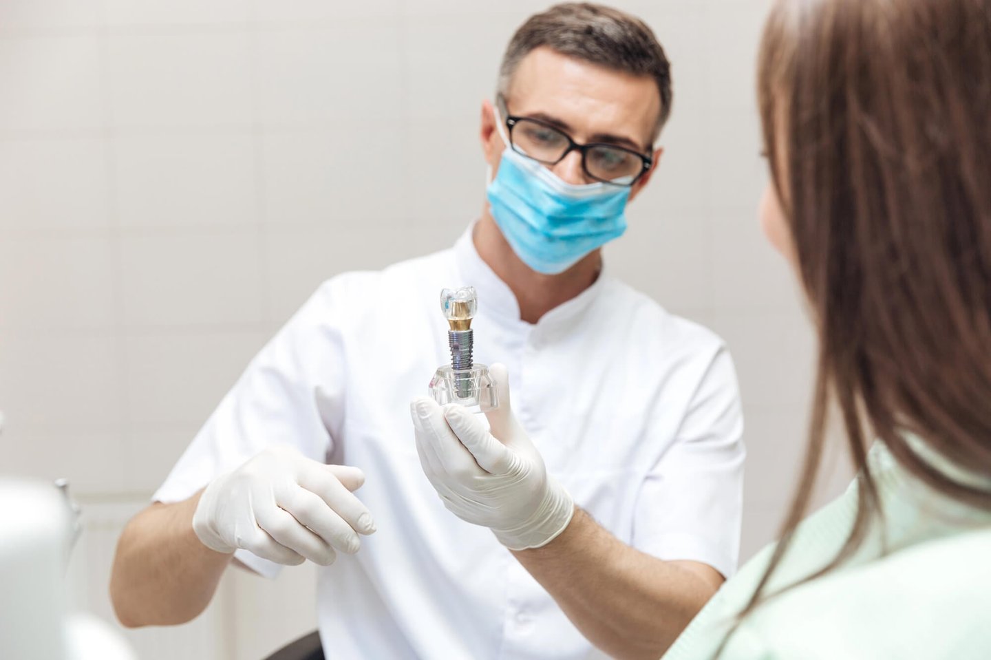 dentist showing patient a model of dental implants in Orlando FL