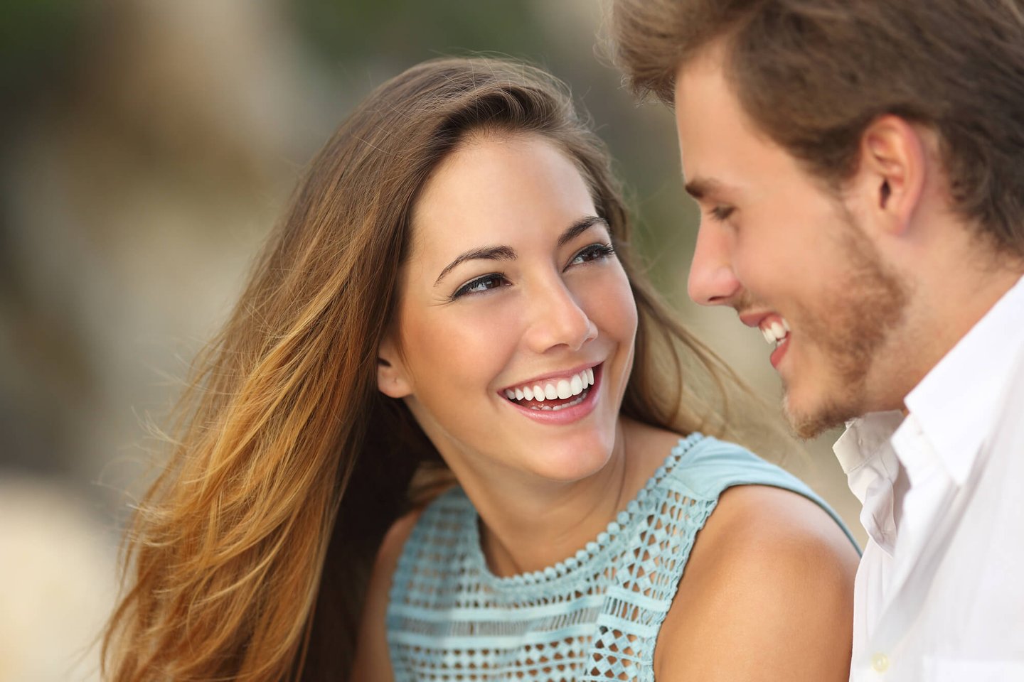 a woman with porcelain veneers smiling at a man in orlando fl 