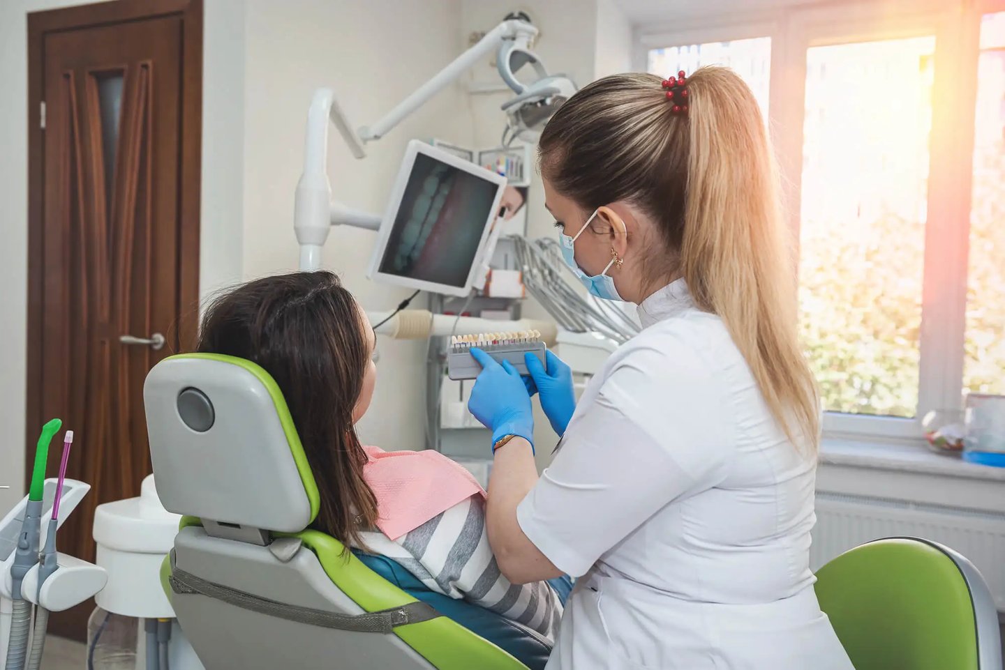 Dentist showing shade guide to patient Dentist in Winter Park, Fl