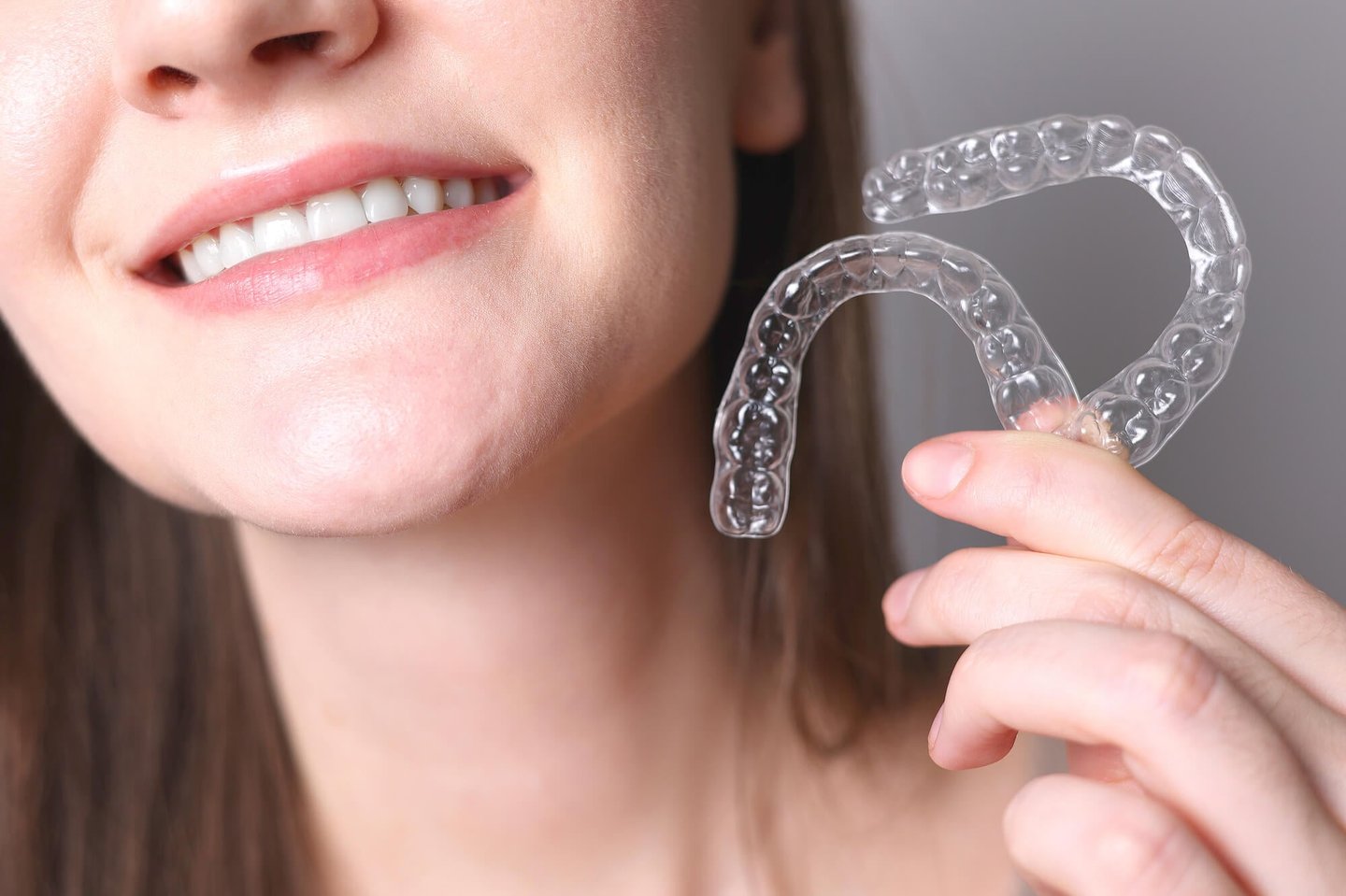 smiling woman holding her new invisalign winter park