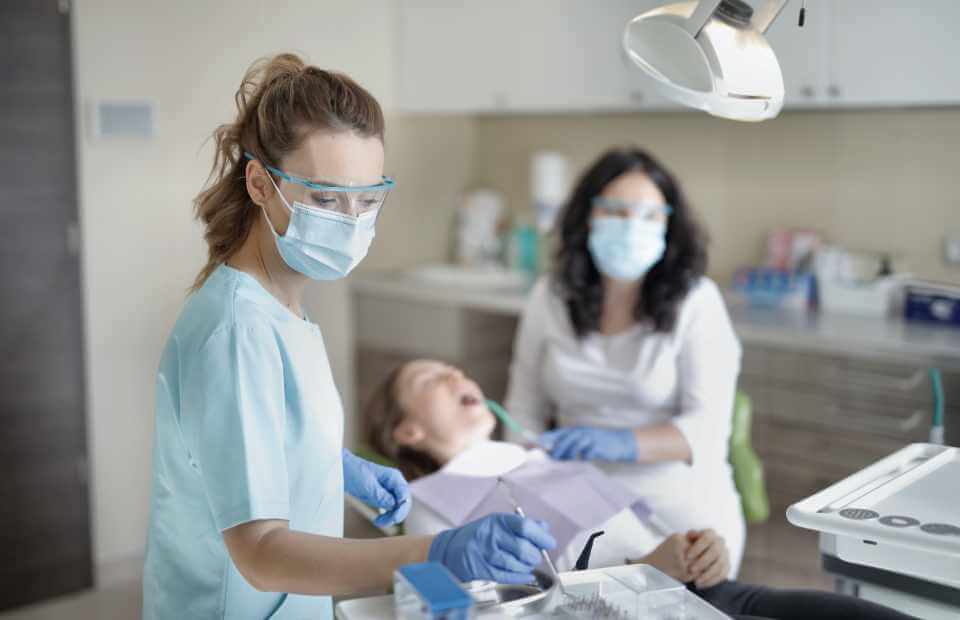 dentist and dental hygienist working with patient
